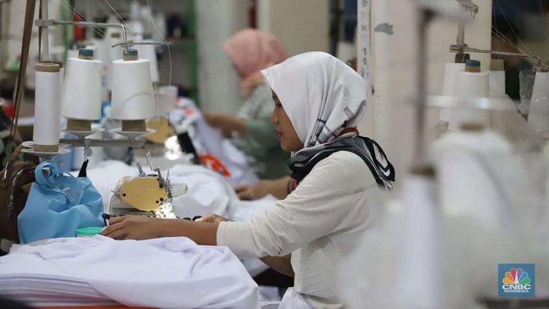 Sejumlah pekerja menyelesaikan kaos pesanan di konveksi Sinergi Adv di kawasan Serengseng Sawah, Jakarta, Rabu (23/10/2024). (CNBC Indonesia/Muhammad Sabki)