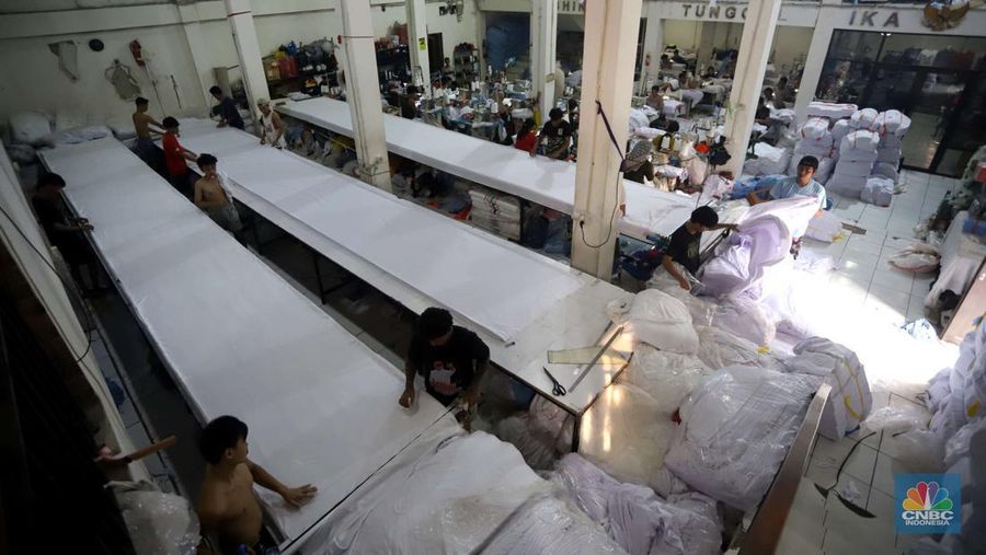 Sejumlah pekerja menyelesaikan kaos pesanan di konveksi Sinergi Adv kawasan Serengseng Sawah, Jakarta, Rabu (23/10/2024). (CNBC Indonesia/Muhammad Sabki)