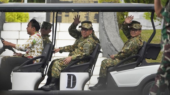 Menteri Koordinator Bidang Pembangunan Manusia dan Kebudayaan Pratikno (tengah), Menteri Koordinator Bidang Pemberdayaan Rakyat Muhaimin Iskandar (kanan) melambaikan tangan ke arah media, sementara Menteri Koordinator Bidang Infrastruktur dan Pengembangan Wilayah Agus Harimurti Yudhoyono (belakang kiri) terlihat menaiki mobil golf saat menghadiri acara retret kabinet di Akademi Militer di Magelang, Jawa Tengah, Indonesia, Jumat, 25 Oktober 2024. (Foto AP/Achmad Ibrahim)