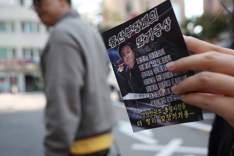 NORTHKOREA-SOUTHKOREA/ People look at a North Korean propaganda leaflet denouncing South Korean President Yoon Suk Yeol and his wife Kim Keon Hee, apparently carried by balloons sent from North Korea, near the Presidential Office in Seoul, South Korea, October 24, 2024. REUTERS/Kim Hong-Ji