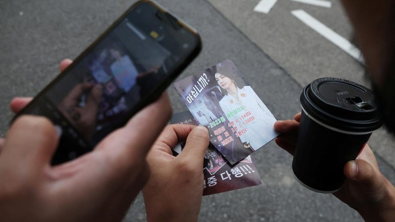 People look at a North Korean propaganda leaflet denouncing South Korean President Yoon Suk Yeol and his wife Kim Keon Hee, apparently carried by balloons sent from North Korea, near the Presidential Office in Seoul, South Korea, October 24, 2024.   REUTERS/Kim Hong-Ji