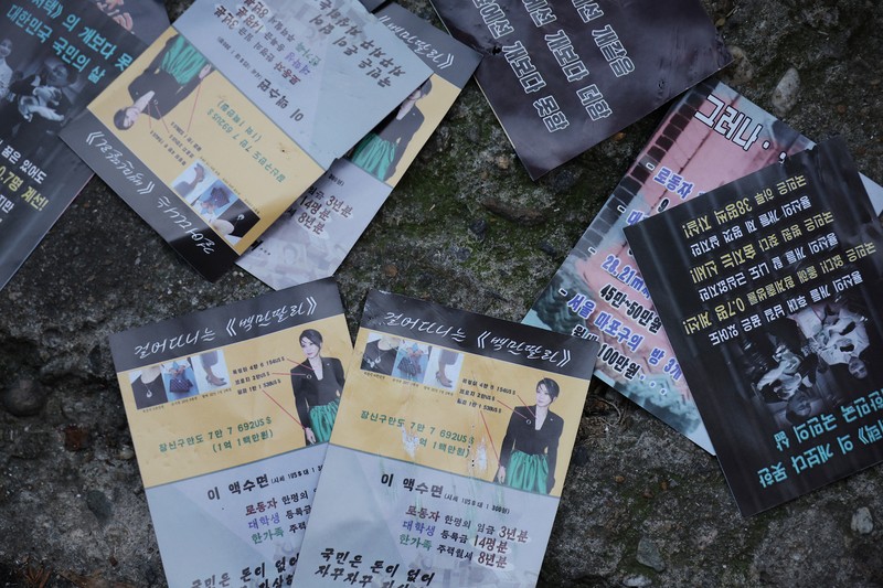 NORTHKOREA-SOUTHKOREA/ People look at a North Korean propaganda leaflet denouncing South Korean President Yoon Suk Yeol and his wife Kim Keon Hee, apparently carried by balloons sent from North Korea, near the Presidential Office in Seoul, South Korea, October 24, 2024. REUTERS/Kim Hong-Ji