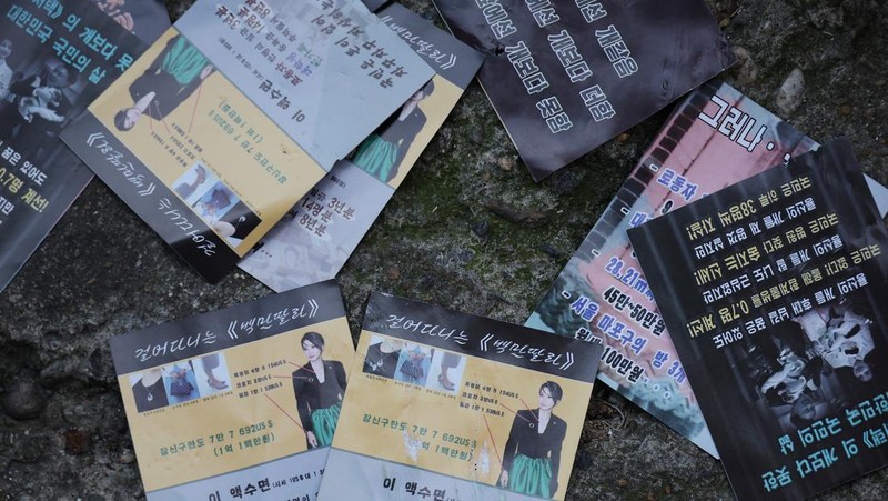 People look at a North Korean propaganda leaflet denouncing South Korean President Yoon Suk Yeol and his wife Kim Keon Hee, apparently carried by balloons sent from North Korea, near the Presidential Office in Seoul, South Korea, October 24, 2024.   REUTERS/Kim Hong-Ji