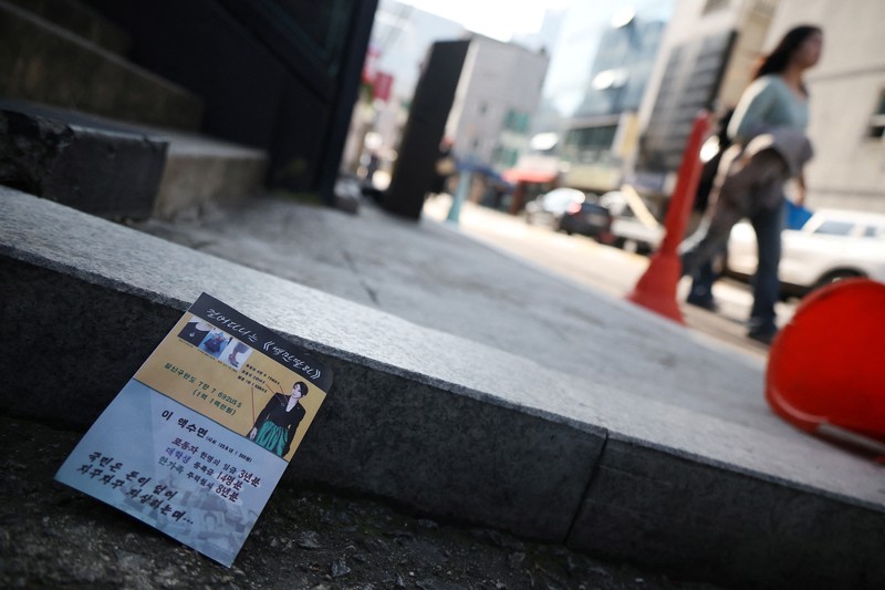 NORTHKOREA-SOUTHKOREA/ People look at a North Korean propaganda leaflet denouncing South Korean President Yoon Suk Yeol and his wife Kim Keon Hee, apparently carried by balloons sent from North Korea, near the Presidential Office in Seoul, South Korea, October 24, 2024. REUTERS/Kim Hong-Ji