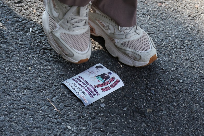 NORTHKOREA-SOUTHKOREA/ People look at a North Korean propaganda leaflet denouncing South Korean President Yoon Suk Yeol and his wife Kim Keon Hee, apparently carried by balloons sent from North Korea, near the Presidential Office in Seoul, South Korea, October 24, 2024. REUTERS/Kim Hong-Ji