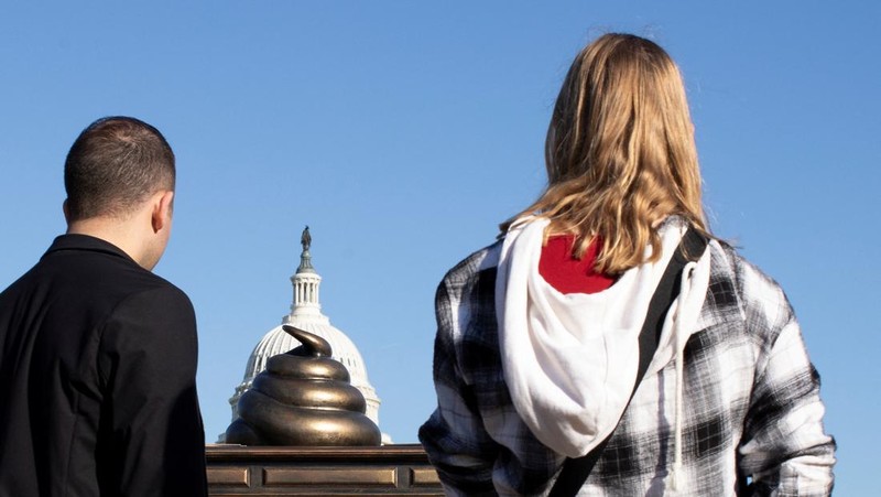 A new temporary statue of a brass-colored desk with a large poop-shaped emoji on top of it, referencing those who attacked the U.S. Capitol on January 6, 2021, is seen near the Capitol in Washington, U.S., October 25, 2024. REUTERS/Kaylee Greenlee Beal