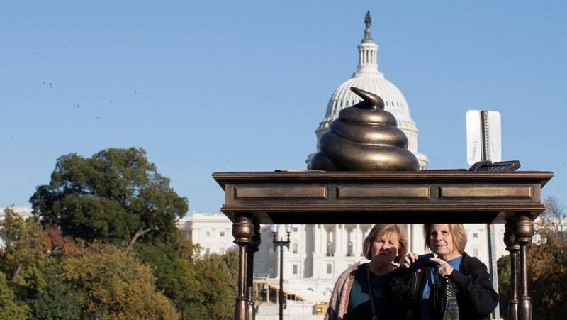 A new temporary statue of a brass-colored desk with a large poop-shaped emoji on top of it, referencing those who attacked the U.S. Capitol on January 6, 2021, is seen near the Capitol in Washington, U.S., October 25, 2024. REUTERS/Kaylee Greenlee Beal