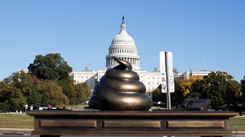 A new temporary statue of a brass-colored desk with a large poop-shaped emoji on top of it, referencing those who attacked the U.S. Capitol on January 6, 2021, is seen near the Capitol in Washington, U.S., October 25, 2024. REUTERS/Kaylee Greenlee Beal