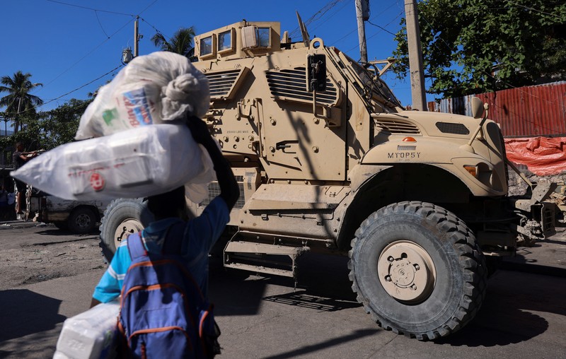 Seorang pria membawa sofa saat melarikan diri dari rumahnya dari kekerasan geng, di Port-au-Prince, Haiti, 26 Oktober 2024. 
 (REUTERS/Ralph Tedy Erol)