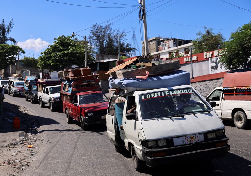 Seorang pria membawa sofa saat melarikan diri dari rumahnya dari kekerasan geng, di Port-au-Prince, Haiti, 26 Oktober 2024. 
 (REUTERS/Ralph Tedy Erol)