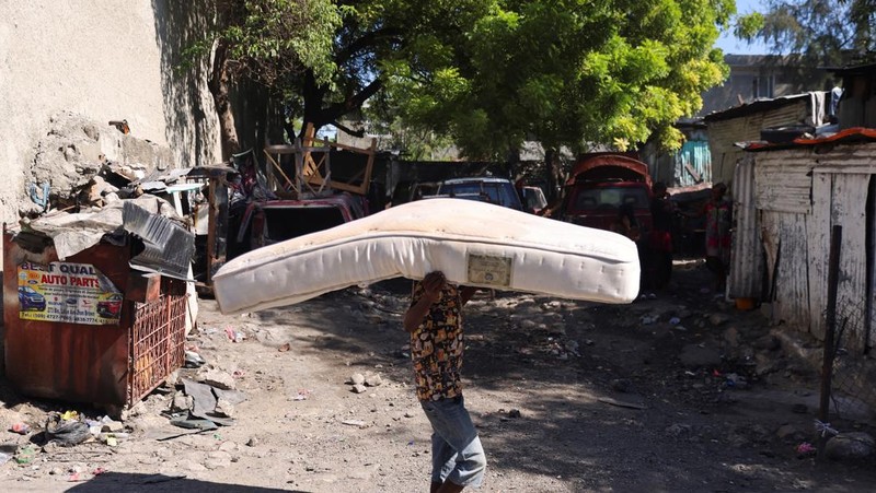 Seorang pria membawa sofa saat melarikan diri dari rumahnya dari kekerasan geng, di Port-au-Prince, Haiti, 26 Oktober 2024. 
 (REUTERS/Ralph Tedy Erol)