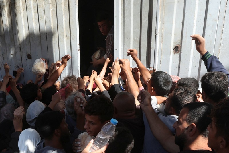 Warga Palestina berkumpul untuk membeli roti dari toko roti, di tengah konflik Israel-Hamas, di Deir Al-Balah di Jalur Gaza tengah, 24 Oktober 2024. Warga Palestina berkumpul untuk membeli roti dari toko roti, di tengah konflik Israel-Hamas, di Deir Al-Balah di Jalur Gaza tengah, 24 Oktober 2024. (REUTERS/Ramadan Abed)