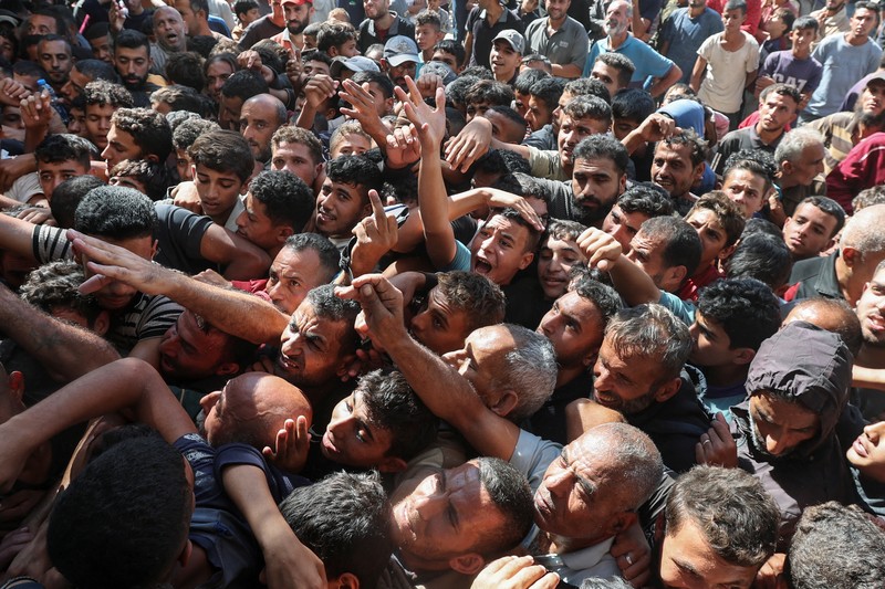 Warga Palestina berkumpul untuk membeli roti dari toko roti, di tengah konflik Israel-Hamas, di Deir Al-Balah di Jalur Gaza tengah, 24 Oktober 2024. Warga Palestina berkumpul untuk membeli roti dari toko roti, di tengah konflik Israel-Hamas, di Deir Al-Balah di Jalur Gaza tengah, 24 Oktober 2024. (REUTERS/Ramadan Abed)