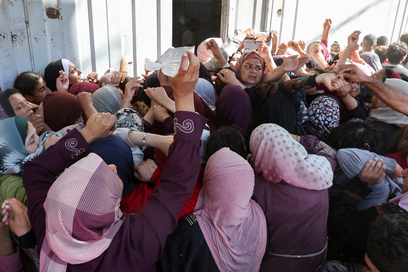 Warga Palestina berkumpul untuk membeli roti dari toko roti, di tengah konflik Israel-Hamas, di Deir Al-Balah di Jalur Gaza tengah, 24 Oktober 2024. Warga Palestina berkumpul untuk membeli roti dari toko roti, di tengah konflik Israel-Hamas, di Deir Al-Balah di Jalur Gaza tengah, 24 Oktober 2024. (REUTERS/Ramadan Abed)