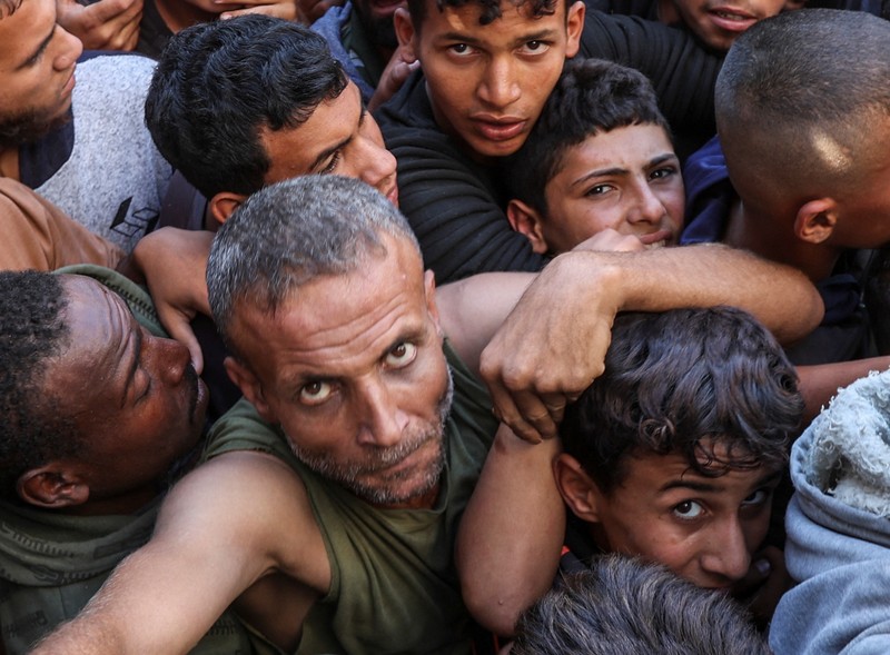 Warga Palestina berkumpul untuk membeli roti dari toko roti, di tengah konflik Israel-Hamas, di Deir Al-Balah di Jalur Gaza tengah, 24 Oktober 2024. Warga Palestina berkumpul untuk membeli roti dari toko roti, di tengah konflik Israel-Hamas, di Deir Al-Balah di Jalur Gaza tengah, 24 Oktober 2024. (REUTERS/Ramadan Abed)