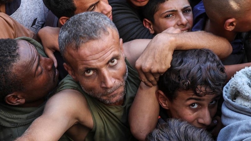 Warga Palestina berkumpul untuk membeli roti dari toko roti, di tengah konflik Israel-Hamas, di Deir Al-Balah di Jalur Gaza tengah, 24 Oktober 2024. (REUTERS/Ramadan Abed)