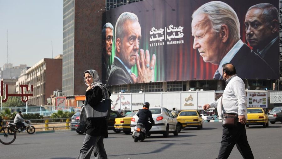 Iranians walk next to an anti-U.S. and Israeli billboard with pictures of Iranian President Masoud Pezeshkian and Iranian Armed Forces Chief of Staff, Major General Mohammad Bagheri and U.S. President Joe Biden and Israel's Prime Minister Benjamin Netanyahu, on a street in Tehran, Iran, October 27, 2024. Majid Asgaripour/WANA (West Asia News Agency) via REUTERS ATTENTION EDITORS - THIS IMAGE HAS BEEN SUPPLIED BY A THIRD PARTY ATTENTION EDITORS - THIS PICTURE WAS PROVIDED BY A THIRD PARTY