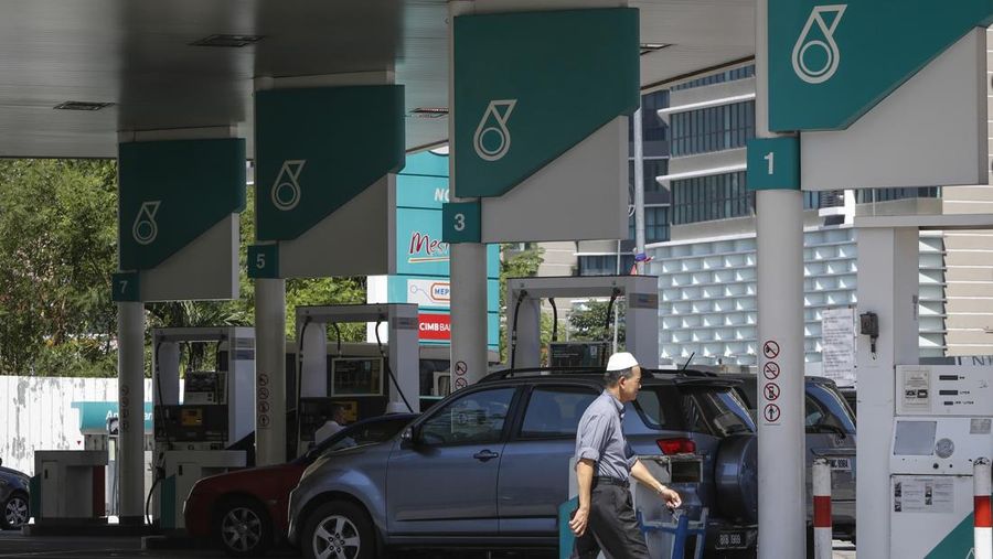 A Malaysian man walks by a Petronas gas station in Kuala Lumpur, Malaysia, Wednesday, March 2, 2016. National oil company Petroliam Nasional Bhd (Petronas) Tuesday, announced a layoff of almost 1,000 staff. (AP Photo/Joshua Paul)