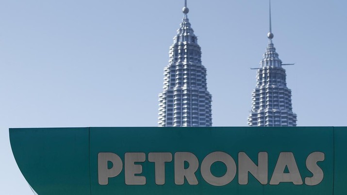 A Petronas gas station signage is pictured against Malaysia's landmark building, Petronas Twin Towers in Kuala Lumpur, Malaysia, Wednesday, March 2, 2016. National oil company Petroliam Nasional Bhd (Petronas) Tuesday, announced a layoff of almost 1,000 staff. (AP Photo/Joshua Paul)