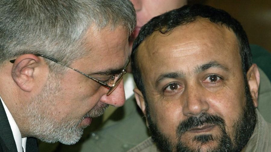 Marwan Barghouti (Kanan) mendengarkan pengacaranya Jawad Boulos selama persidangan di pengadilan distrik Tel Aviv 12 Desember 2002. (Photo by SVEN NACKSTRAND / POOL / AFP/File Foto)
