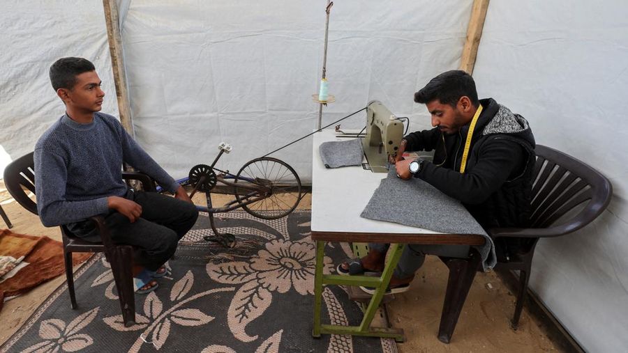 Warga Palestina yang mengungsi menyalakan api di tenda mereka saat mereka tinggal di pemakaman, di tengah konflik Israel-Hamas, di Khan Younis, di Jalur Gaza selatan, 27 Oktober 2024. (REUTERS/Mohammed Salem)