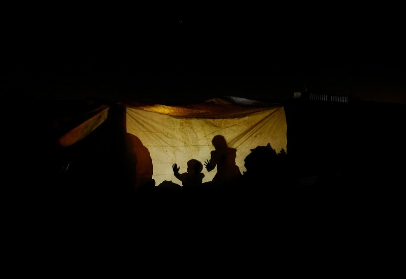 Warga Palestina yang mengungsi menyalakan api di tenda mereka saat mereka tinggal di pemakaman, di tengah konflik Israel-Hamas, di Khan Younis, di Jalur Gaza selatan, 27 Oktober 2024. Warga Palestina yang mengungsi menyalakan api di tenda mereka saat mereka tinggal di pemakaman, di tengah konflik Israel-Hamas, di Khan Younis, di Jalur Gaza selatan, 27 Oktober 2024. (REUTERS/Mohammed Salem)