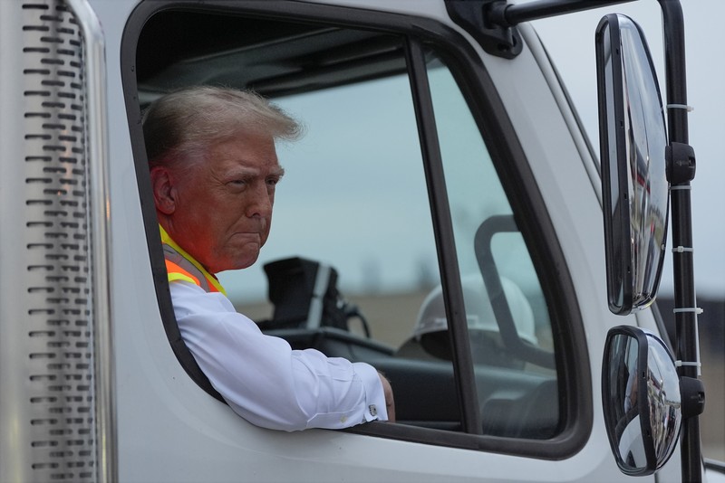 USA-ELECTION/TRUMP Republican presidential nominee and former U.S. President Donald Trump sits inside garbage truck as he wears a high-vis vest, on tarmac at Green Bay Austin Straubel International Airport in Green Bay, Wisconsin, U.S., October 30, 2024. REUTERS/Brendan McDermid