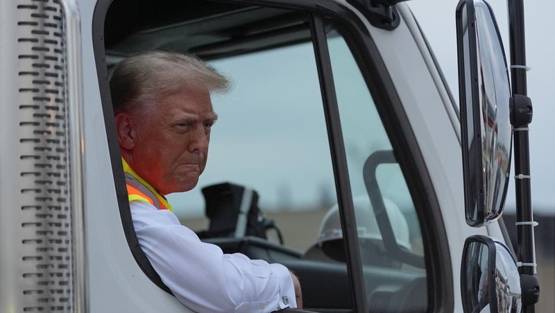 Republican presidential nominee and former U.S. President Donald Trump sits inside garbage truck as he wears a high-vis vest, on tarmac at Green Bay Austin Straubel International Airport in Green Bay, Wisconsin, U.S., October 30, 2024. REUTERS/Brendan McDermid