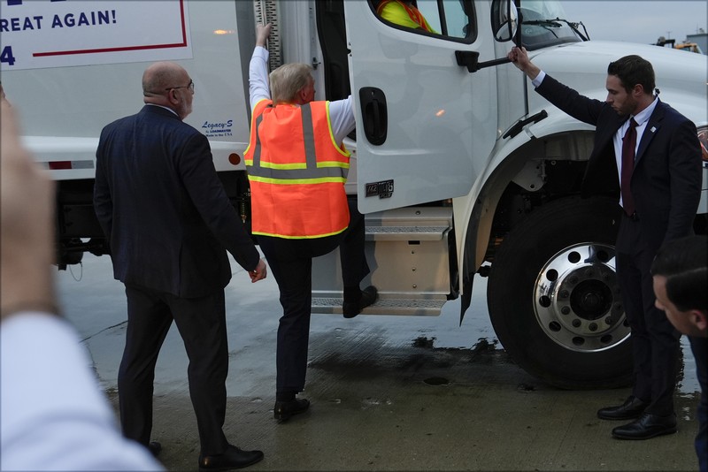 Republican presidential nominee and former U.S. President Donald Trump sits inside garbage truck as he wears a high-vis vest, on tarmac at Green Bay Austin Straubel International Airport in Green Bay, Wisconsin, U.S., October 30, 2024. REUTERS/Brendan McDermid