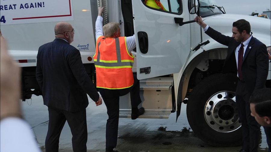 Republican presidential nominee and former U.S. President Donald Trump sits inside garbage truck as he wears a high-vis vest, on tarmac at Green Bay Austin Straubel International Airport in Green Bay, Wisconsin, U.S., October 30, 2024. REUTERS/Brendan McDermid