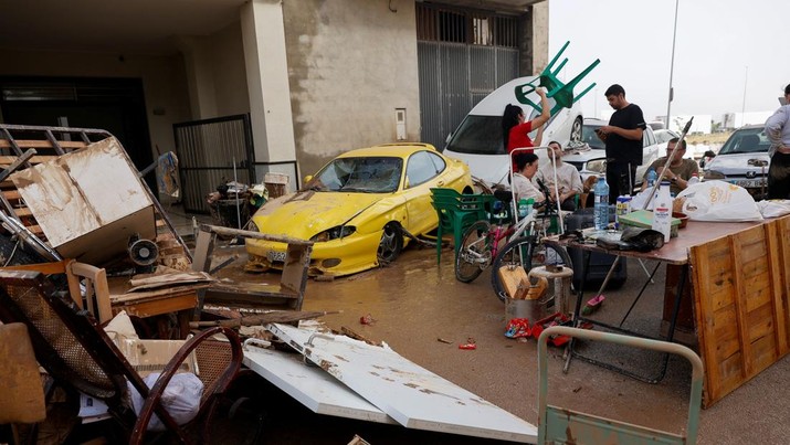 Meseguer Serrano family gather next to their belongings and damaged cars after torrential rains caused flooding in Guadassuar, Valencia region, Spain, October 30, 2024. REUTERS/Eva Manez