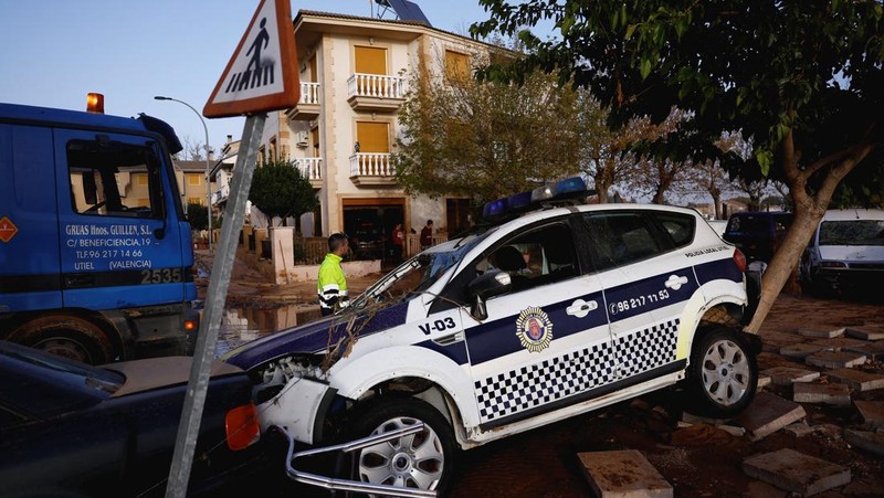 Residents stand outside their homes next to damaged belongings after floods in Utiel, Spain, October 30, 2024. REUTERS/Susana Vera