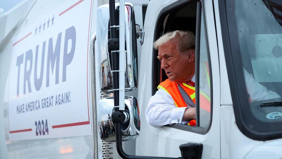 Republican presidential nominee and former U.S. President Donald Trump sits inside garbage truck as he wears a high-vis vest, on tarmac at Green Bay Austin Straubel International Airport in Green Bay, Wisconsin, U.S., October 30, 2024. REUTERS/Brendan McDermid