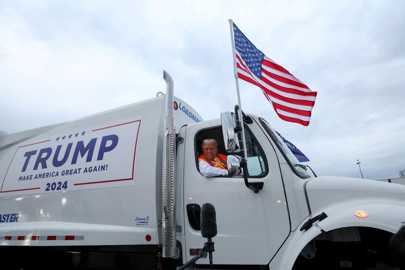 USA-ELECTION/TRUMP Republican presidential nominee and former U.S. President Donald Trump sits inside garbage truck as he wears a high-vis vest, on tarmac at Green Bay Austin Straubel International Airport in Green Bay, Wisconsin, U.S., October 30, 2024. REUTERS/Brendan McDermid