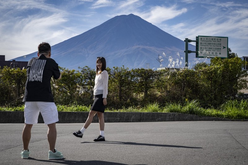 Warga beraktivitas dengan latar belakang Gunung Fuji, gunung tertinggi di Jepang dengan ketinggian 3.776 meter (12.460 kaki), di Fujikawaguchiko, prefektur Yamanashi pada tanggal 31 Oktober 2024. (AFP/YUICHI YAMAZAKI) Warga beraktivitas dengan latar belakang Gunung Fuji, gunung tertinggi di Jepang dengan ketinggian 3.776 meter (12.460 kaki), di Fujikawaguchiko, prefektur Yamanashi pada tanggal 31 Oktober 2024. (AFP/YUICHI YAMAZAKI)