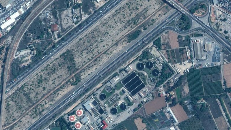 Kombinasi gambar satelit yang dibagikan oleh Maxar Technologies yang dibuat pada tanggal 31 Oktober 2024 ini menunjukkan pabrik pengolahan air Valencia dan jalan raya v30 sebelum (atas) dan setelah banjir bandang. (AFP/HANDOUT)