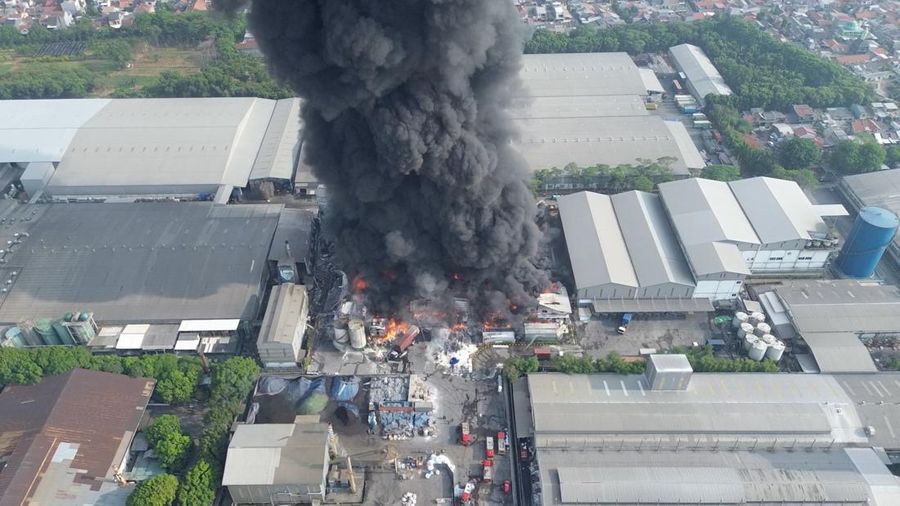 Pemandangan drone menunjukkan asap dan api mengepul di sebuah pabrik minyak goreng, di Bekasi, provinsi Jawa Barat, Indonesia, 1 November 2024, dalam tangkapan layar yang diperoleh dari video media sosial. (ILHAM APRIYANTO/via REUTERS)