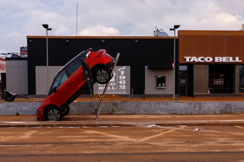 EUROPE-WEATHER/SPAIN-STORM A firefighter searches for possible victims inside cars damaged following heavy rains that caused floods, in Alfafar, Valencia, Spain, November 1, 2024. REUTERS/Susana Vera