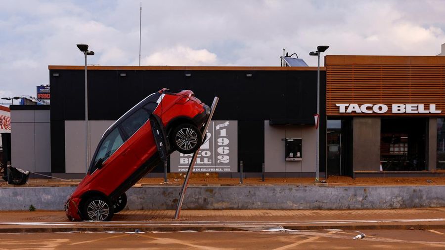 A firefighter searches for possible victims inside cars damaged following heavy rains that caused floods, in Alfafar, Valencia, Spain, November 1, 2024. REUTERS/Susana Vera