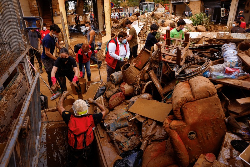 Seorang wanita membersihkan lumpur tebal, akibat banjir akibat hujan lebat, di Sedavi, dekat Valencia, Spanyol, 3 November 2024. (REUTERS/Susana Vera)