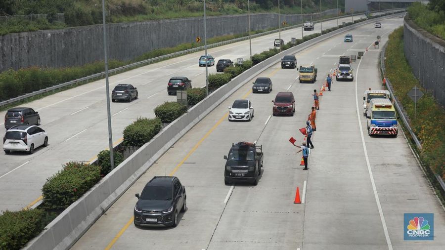 Sejumlah pekerja membersihkan sisa-sisa tanah yang memasuki ruas jalan Tol Serpong - Cinere, Senin (4/11/2024). (²©²ÊÍøÕ¾/Tri Susilo)