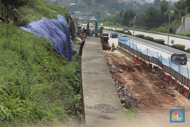 Sejumlah pekerja membersihkan sisa-sisa tanah yang memasuki ruas jalan Tol Serpong - Cinere, Senin (4/11/2024). Sejumlah pekerja membersihkan sisa-sisa tanah yang memasuki ruas jalan Tol Serpong - Cinere, Senin (4/11/2024). (CNBC Indonesia/Tri Susilo)