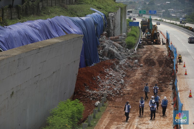 Sejumlah pekerja membersihkan sisa-sisa tanah yang memasuki ruas jalan Tol Serpong - Cinere, Senin (4/11/2024). Sejumlah pekerja membersihkan sisa-sisa tanah yang memasuki ruas jalan Tol Serpong - Cinere, Senin (4/11/2024). (CNBC Indonesia/Tri Susilo)