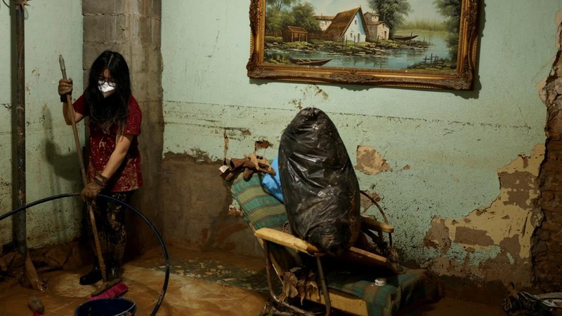 Seorang wanita membersihkan lumpur tebal, akibat banjir akibat hujan lebat, di Sedavi, dekat Valencia, Spanyol, 3 November 2024. (REUTERS/Susana Vera)