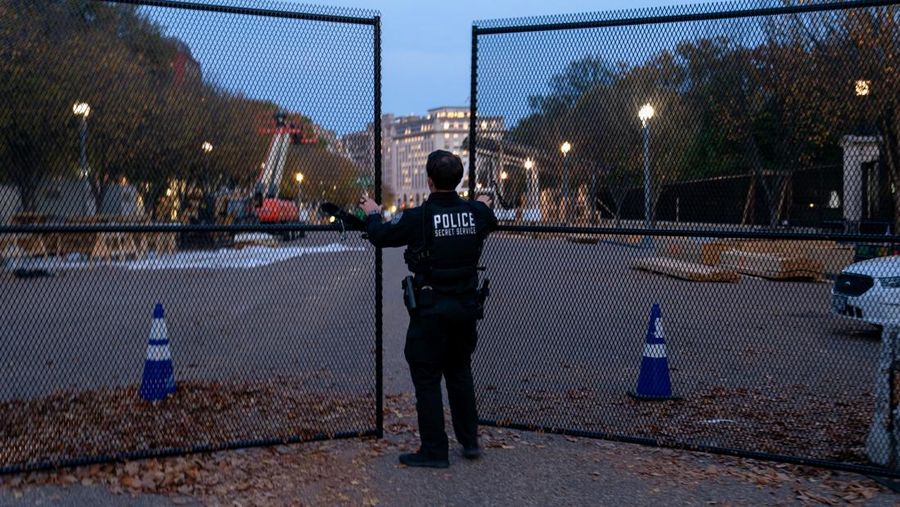 Seorang anggota Dinas Rahasia AS menutup gerbang keamanan di sepanjang Pennsylvania Avenue dekat Gedung Putih pada hari sebelum pemilihan presiden AS di Washington, AS, 4 November 2024. (REUTERS/Nathan Howard)