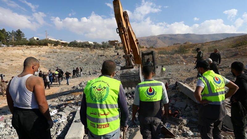 Bendera Hizbullah berkibar di lokasi yang rusak akibat serangan Israel di kota Al-Ain di wilayah Baalbek, di tengah permusuhan yang sedang berlangsung antara Hizbullah dan pasukan Israel, di Lebanon, 6 November 2024. (REUTERS/Mohammed Yassin)