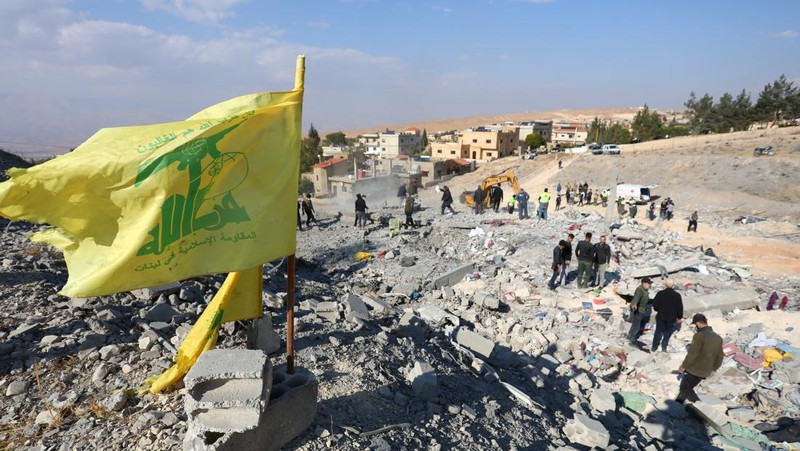 Bendera Hizbullah berkibar di lokasi yang rusak akibat serangan Israel di kota Al-Ain di wilayah Baalbek, di tengah permusuhan yang sedang berlangsung antara Hizbullah dan pasukan Israel, di Lebanon, 6 November 2024. (REUTERS/Mohammed Yassin)