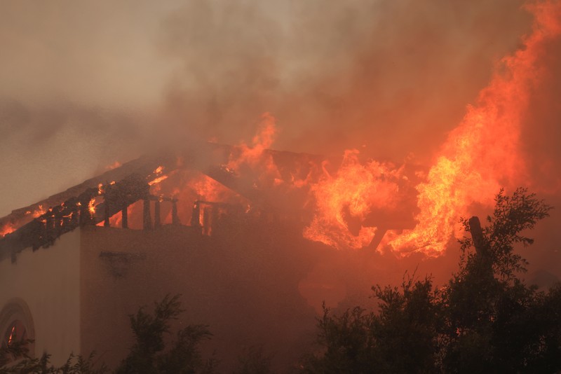 Pemandangan menunjukkan properti yang rusak terbakar, sementara asap mengepul dari Kebakaran Gunung di Camarillo, California, AS, 6 November 2024. Pemandangan menunjukkan properti yang rusak terbakar, sementara asap mengepul dari Kebakaran Gunung di Camarillo, California, AS, 6 November 2024. (REUTERS/David Swanson)