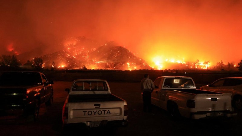 Pemandangan menunjukkan properti yang rusak terbakar, sementara asap mengepul dari Kebakaran Gunung di Camarillo, California, AS, 6 November 2024. (REUTERS/David Swanson)