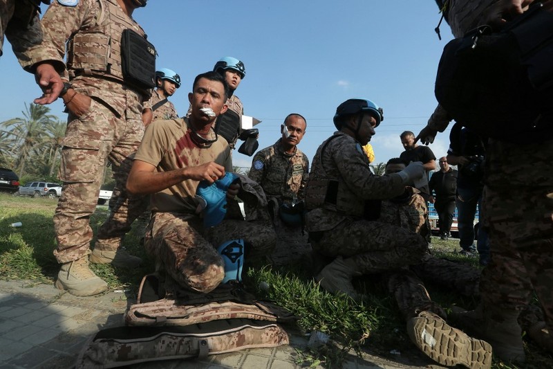 Anggota pasukan penjaga perdamaian UNIFIL duduk di pinggir jalan di lokasi serangan Israel di pintu masuk utara kota selatan Sidon pada, Kamis (7/11/2024).  UNIFIL telah merilis pernyataan mengenai serangan Israel di pinggiran Sidon di Lebanon. Dikatakan bahwa pasukan penjaga perdamaian yang “baru tiba” berada di sekitar serangan pesawat tak berawak, yang mengakibatkan lima dari mereka terluka. (Photo by MAHMOUD ZAYYAT / AFP)